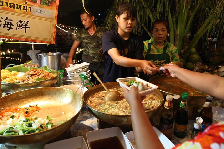 Females Making and Serving Food At An Asian Food Market