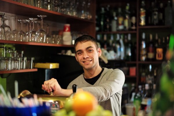 Male Bartender In A UK Pub On A Working Holiday.