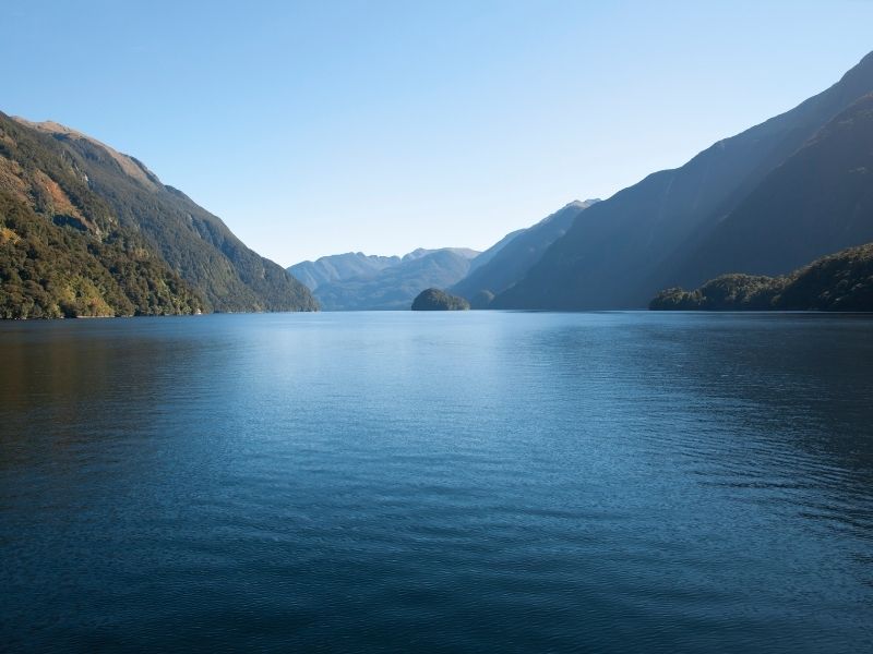 Doubtful Sound On New Zealand's South Island Is A Beautiful Sunken Valley Full Of Water Surrounded By Tall Mountains.