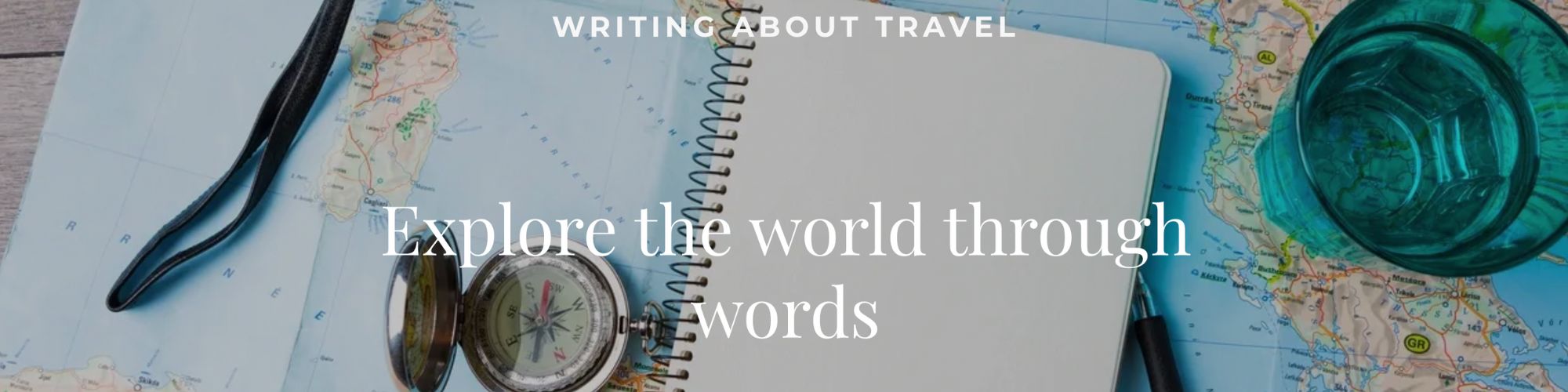 WritingAboutTravelHead Desk with a writing pad, pen and a map for someone writing about travel.