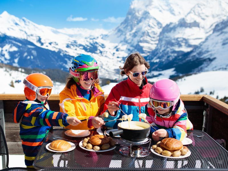 family enjoying lunch on the ski slopes