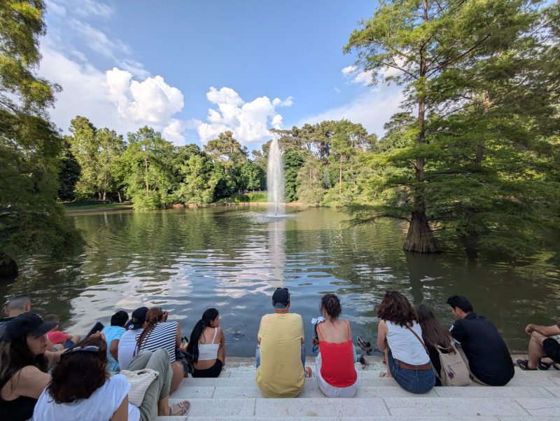 people sitting by a pond in Retiro Park, Madrid