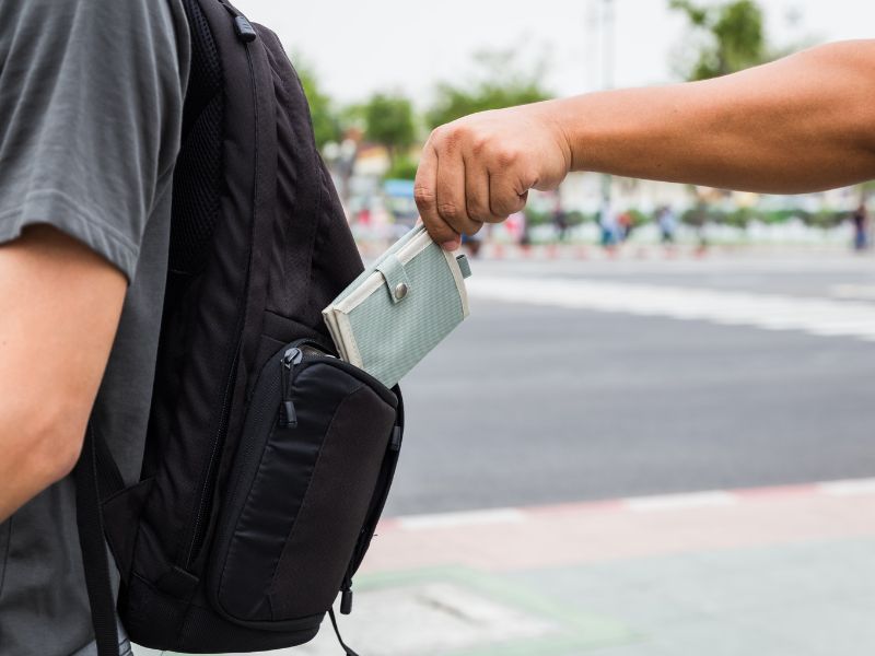 pickpocket pickpocket - person taking a wallet from a backpack